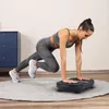A woman is doing a workout on a vibration plate in a room. Náhľad obrázku produktu