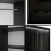 A collage of four images showing different views of a black wardrobe, including its interior, a bed, and its exterior with sliding doors. Produktbild-Vorschau