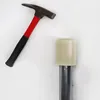 A hammer and a metal pole with a white cap are shown against a white background. Voir les images du produit