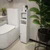 A white toilet paper cabinet is shown next to a toilet in a bathroom. Produktbild-Vorschau