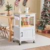 A kitchen cart is shown next to a dining table and a Christmas tree, decorated for the holidays. Produktbild-Vorschau