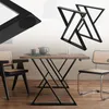 A dining table with black metal legs and a wooden top, set with a teapot and cups. Two chairs are visible, one black and one chrome with cane seating. Two additional table legs are shown in the upper right corner. Náhled obrázku produktu
