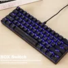 A black mechanical keyboard with blue backlighting is shown on a wooden desk. Podgląd zdjęcia produktu