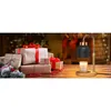 A candle warmer lamp is shown on a wooden table next to a stack of Christmas gifts, with a fireplace and Christmas tree in the background. Náhled obrázku produktu