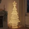 A lighted Christmas tree with a star on top, placed indoors next to a fireplace and curtains. Podgląd zdjęcia produktu