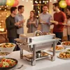 People at a buffet-style event with food served from a chafing dish. Podgląd zdjęcia produktu