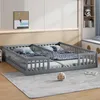 A children's bedroom with two twin beds side-by-side, featuring grey wooden frames and railings. The beds are made with patterned bedding and pillows. A small, textured ball sits on the rug in front of the beds. Anteprima dell’immagine prodotto