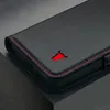A close-up shot of a black leather phone case with red stitching and a red bull logo. Anteprima dell’immagine prodotto