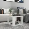 A white side table with books and a vase of greenery on it, placed in a living room setting next to a sofa. Produktbild-Vorschau