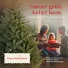 A family is gathered around a Christmas tree, with a close-up of the tree's branches and a label indicating it is flame-retardant. Produktbild-Vorschau