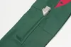 Close-up view of a green work pant pocket with a folding ruler inserted. Náhľad obrázku produktu