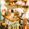 A miniature cafe scene with a counter, shelves, and various cafe items. Anteprima dell’immagine prodotto