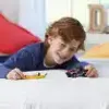 A young boy is lying on a white surface, playing with toy cars. Produktbild-Vorschau