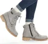 A pair of grey lace-up ankle boots worn with cuffed blue jeans and white socks. Anteprima dell’immagine prodotto