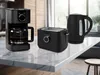 A black coffee maker, toaster, and kettle are displayed on a marble countertop in a kitchen setting. Produktbild-Vorschau
