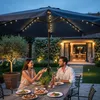 A couple is enjoying a romantic dinner outdoors under a patio umbrella at dusk. Náhľad obrázku produktu
