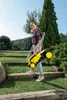A young woman is carrying a yellow and black lawnmower up a set of wooden steps in a garden. Produktbild-Vorschau