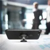 A black smartphone with a magnetic car mount attached is placed on a desk with charts and graphs. Two blurred figures in business attire are visible in the background. Náhľad obrázku produktu