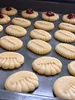 A close-up shot of freshly baked cookies arranged on a baking sheet. Anteprima dell’immagine prodotto