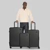 A man stands behind three black suitcases of varying sizes. Produktbild-Vorschau