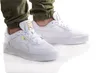 A pair of white Puma sneakers with gold accents, worn by a person wearing green pants. Produktbild-Vorschau