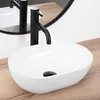 A white oval basin sink with a black faucet is shown on a wooden countertop, with a reflection in a mirror behind it. Náhľad obrázku produktu