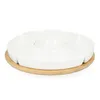 A white ceramic divided serving dish with a central compartment, resting on a round wooden base, isolated on a white background. Náhled obrázku produktu