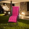 A pink cushion on a recliner chair placed on a lawn at night, with ambient lighting from lamps and stairs. Náhled obrázku produktu