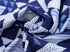 A close-up view of folded blue and white patterned fabric. Produktbild-Vorschau