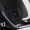 A compact subwoofer is placed on the floor of a car, tucked under the seat. Voir les images du produit