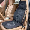 A black massage seat mat is placed on a tan car seat, with a controller visible on the center console. Náhľad obrázku produktu