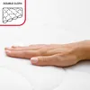 A hand resting on a white quilted mattress surface. Anteprima dell’immagine prodotto