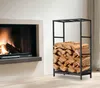 A fireplace with a fire burning and a black metal firewood rack filled with logs next to it. Podgląd zdjęcia produktu