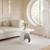 A modern living room with a white sofa, a round coffee table with a cat inside, and a large circular window. Produktbild-Vorschau