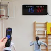 A scoreboard and remote control in a gymnasium with children playing. Náhled obrázku produktu