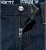 A close-up view of the zipper and button area of dark blue denim jeans. Podgląd zdjęcia produktu