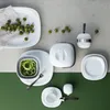 A flat lay of white tableware and green berries on a two-toned background. Anteprima dell’immagine prodotto