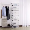 A white modular shoe rack with 10 transparent compartments is shown next to a white clothing rack with clothes and a scarf. Two fabric storage drawers are on the bottom shelf of the clothing rack, and a pair of brown high heels are on the floor. Produktbild-Vorschau