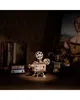 A wooden model of a film projector sits on a wooden surface, with books and a painting in the background. Produktbild-Vorschau