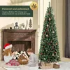 A Christmas tree is decorated and placed next to a fireplace, with two children sitting on the floor in front of it. Podgląd zdjęcia produktu