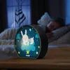 A child sleeping in bed with a night light on a bedside table. Voir les images du produit