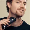 A man is shaving his neck with an electric razor. Produktbild-Vorschau