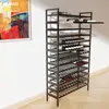 A tall, black metal wine rack filled with wine bottles, standing against a white wall next to a colorful abstract painting. Anteprima dell’immagine prodotto