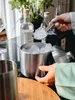 A person is adding ice to an ice bucket with a scoop. Anteprima dell’immagine prodotto