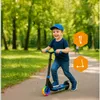 A young boy rides an electric scooter in a park. Anteprima dell’immagine prodotto