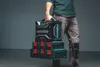 A person is holding a stack of Metabo toolboxes. Podgląd zdjęcia produktu