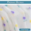 Close-up of white sheer fabric with colorful pom-pom embellishments. Produktbild-Vorschau