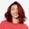 A woman with red hair smiles at the camera, wearing a red and pink striped shirt. Anteprima dell’immagine prodotto