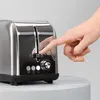 A hand is pressing the lever of a stainless steel toaster. Produktbild-Vorschau