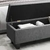 A close-up view of an open storage bench with folded white towels inside. Produktbild-Vorschau